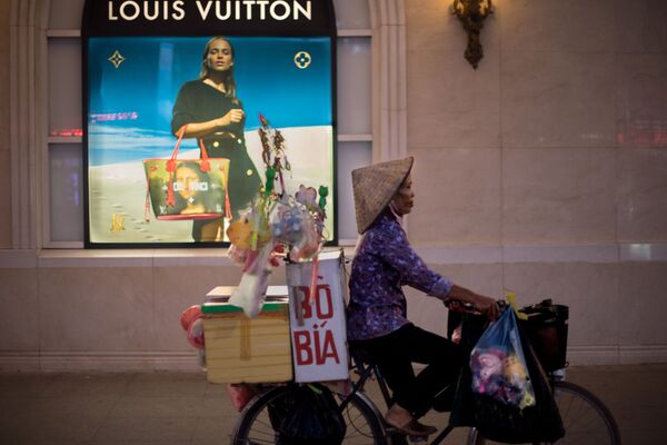 Người bán hàng rong đạp xe ngang qua trung tâm thương mại, Hà Nội, Việt Nam - Sputnik Việt Nam
