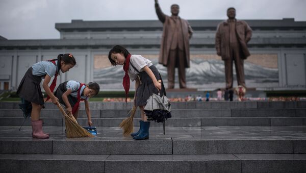 Bình Nhưỡng. Những đứa trẻ lau bậc cầu thang phía trước tượng đài lãnh tụ Kim Nhật Thành và Kim Chính Nhật. - Sputnik Việt Nam