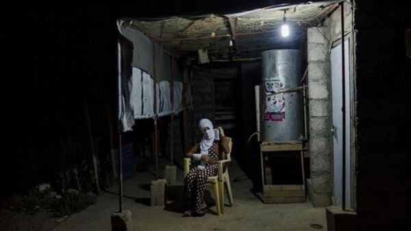 Souhayla ngồi bên ngoài túp lều của người chú ở Shariya, Iraq hôm 20/7. - Sputnik Việt Nam