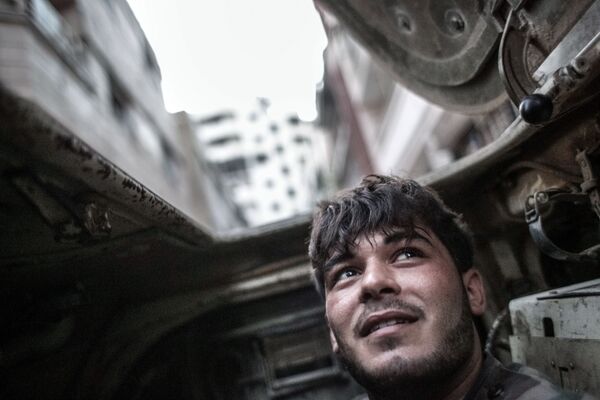 Quân nhân chính phủ Syria trong xe bọc thép thời điểm đụng độ với các tay súng ở trung tâm Homs. - Sputnik Việt Nam
