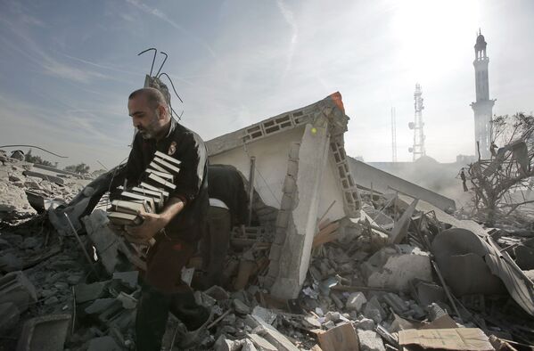 Gaza. Người đàn ông bê kinh Koran ra khỏi tòa nhà bị đánh bom... - Sputnik Việt Nam