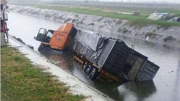 Xe container lật ngửa dưới sông sau khi gây tai nạn. - Sputnik Việt Nam
