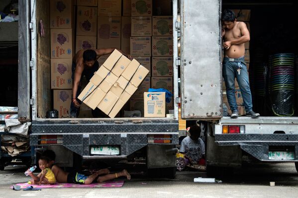 Manila. Những đứa trẻ Philippines tìm thấy bóng rợp...dưới một chiếc xe tải. - Sputnik Việt Nam