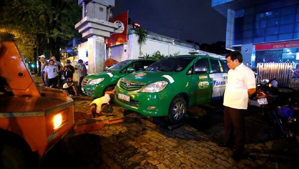 Hai chiếc xe taxi đậu lấn chiếm vỉa hè đường Nguyễn Thị Minh Khai (Q.1, TP.HCM) bị ông Đoàn Ngọc Hải chỉ đạo niêm phong chở về đồn vì đậu lấn chiếm vỉa hè và vắng chủ - Sputnik Việt Nam