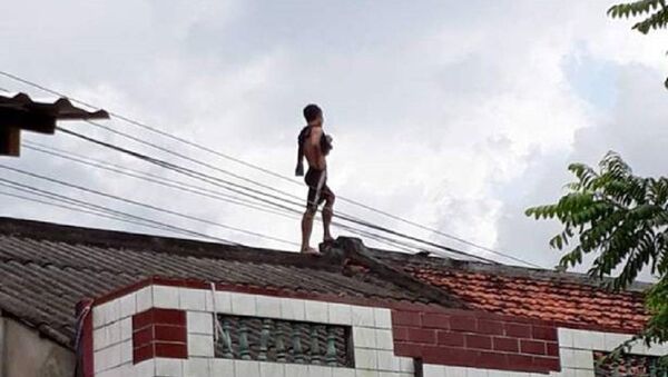 Nam thanh niên trèo lên nóc nhà dân - Sputnik Việt Nam