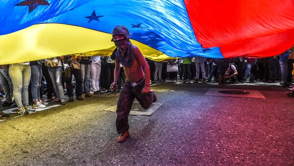 Cậu bé chạy dưới lá cờ Venezuela trong cuộc biểu tình phản đối của các nhà báo ở Caracas - Sputnik Việt Nam