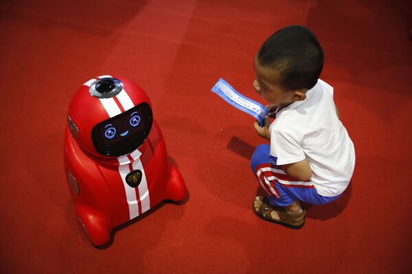 Trung Quốc. Đứa bé theo dõi robot tự học tại Hội nghị Robot toàn thế giới ở Bắc Kinh. - Sputnik Việt Nam