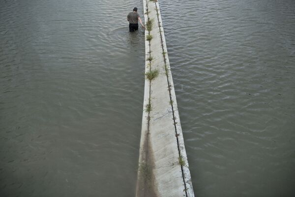 Người lái xe tải kiểm tra mực nước lụt trên đường cho xe chạy... - Sputnik Việt Nam