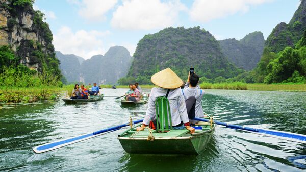 Khách du lịch trên thuyền trong cuộc du ngoạn dọc sông Ngô Đồng ở Việt Nam - Sputnik Việt Nam