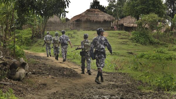 In this Friday, July 14, 2017 photo, Myanmar Border Guard Police (BGP) officers walk along a path ahead of journalists in Tin May village, in which Myanmar government and military claim the existence of Muslim terrorists in Buthidaung, Rakhine State, Myanmar. - Sputnik Việt Nam