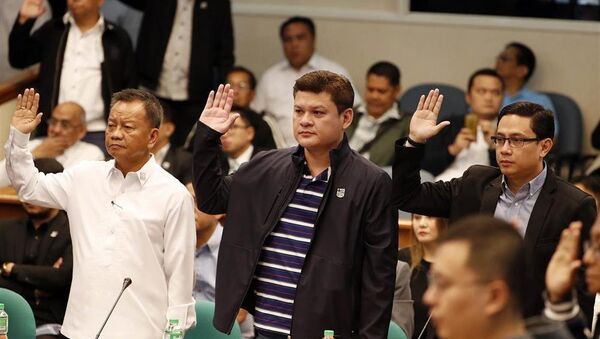 Cục trưởng Hải quan Philippines Isisdro Lapena (trái), Phó Thị trưởng Davao Paolo Duterte - con trai Tổng thống Rodrigo Duterte (giữa) và Maneses Carpio, con rể ông Rodrigo Duterte (phải), tuyên thệ trong buổi điều trần tại Thượng viện hôm 7.9. - Sputnik Việt Nam