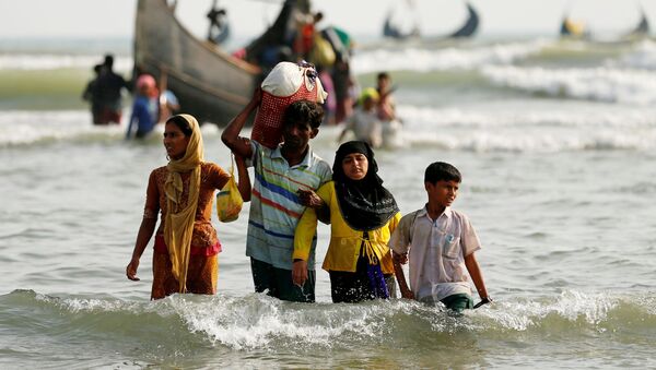 Dân tị nạn người Rohingya đổ lên bờ với đồ đạc của họ sau khi vượt biên giới đường biển giữa Bangladesh và Myanmar. - Sputnik Việt Nam