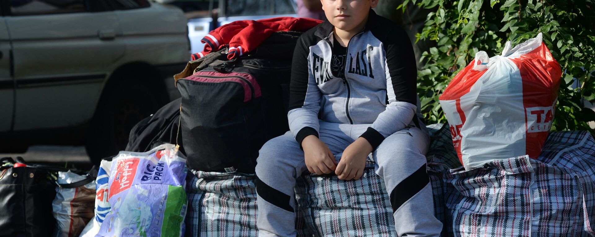 Cậu bé từ vùng Donetsk trước khi lên chuyến xe đưa người tị nạn đến Nga - Sputnik Việt Nam, 1920, 28.08.2022