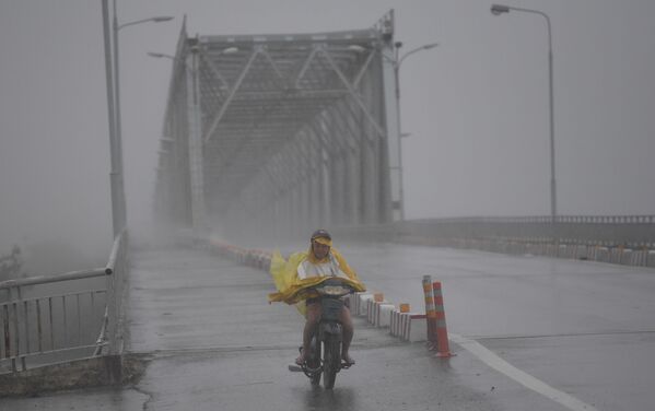 Cô gái Việt chạy xe trên con đường trống rỗng trong cơn bão “Doksuri”. - Sputnik Việt Nam