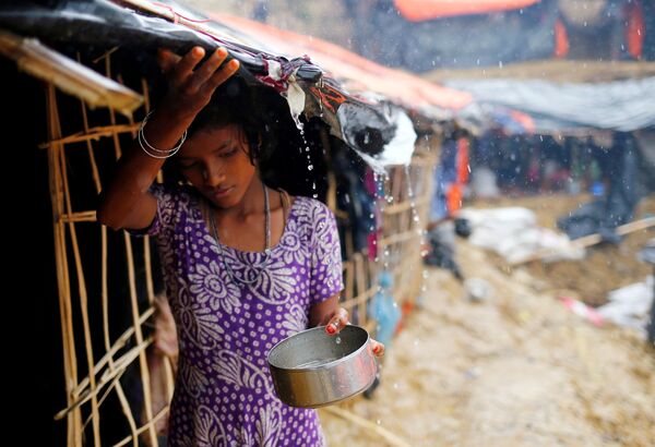Bé gái tị nạn Rohingya hứng  nước mưa để dùng trong trại tị nạn tạm thời ở Cox Bazar, Bangladesh - Sputnik Việt Nam