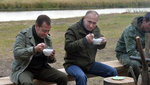 Tổng thống Nga Vladimir Putin (thứ hai bên phải) và Thủ tướng Dmitry Medvedev (bên trái) ăn súp cá sau chuyến dạo chơi bằng thuyền  theo hồ Ilmen - Sputnik Việt Nam