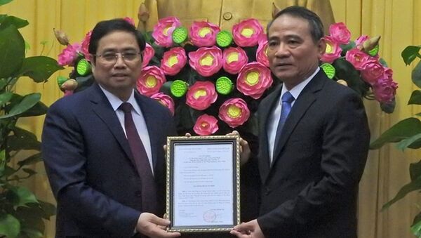 Ông Phạm Minh Chính, ủy viên Bộ Chính trị, trưởng Ban Tổ chức trung ương (trái) trao quyết định cho ông Trương Quang Nghĩa - Sputnik Việt Nam
