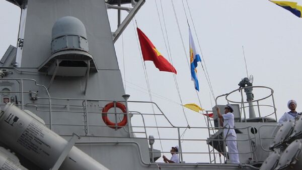 Thiếu tá Lê Đức Thảnh - thuyền trưởng tàu 383 - thực hiện nghi thức kéo quốc kỳ và cờ hải quân - Sputnik Việt Nam