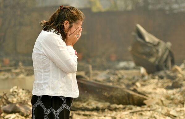Một phụ nữ đang khóc trước căn nhà bị cháy ở Santa Rosa, California, Mỹ. - Sputnik Việt Nam