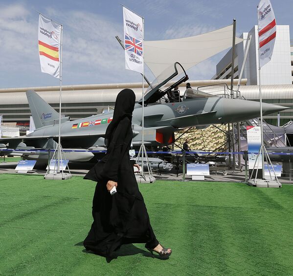 2013. Vị khách nữ tham quan triển lãm IDEX ở UAE trên nền chiếc máy bay chiến đấu Eurofighter Typhoon. - Sputnik Việt Nam