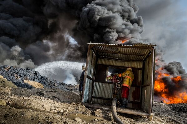 Đám cháy mỏ dầu Qayyarah (Qayyarah burning oil fields) do nhiếp ảnh gia Alessandro Rota chụp ngày 31 tháng 10 năm 2016 tại Iraq, nơi các chiến binh IS (tổ chức khủng bố bị cấm ở Nga) đốt cháy mỏ dầu trước khi tháo chạy. - Sputnik Việt Nam