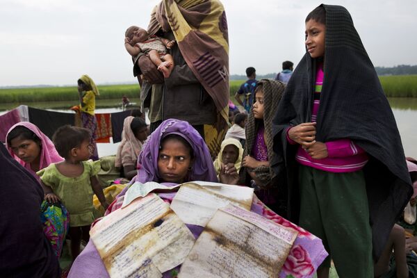Một phụ nữ người Rohingya chạy trốn từ Myanmar đến Bangladesh đang hong khô giấy tờ ở biên giới - Sputnik Việt Nam