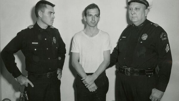 Lee Harvey Oswald, accused of assassinating former U.S. President John F. Kennedy, is pictured with Dallas police Sgt. Warren (R) and a fellow officer in Dallas, in this handout image taken on November 22, 1963. - Sputnik Việt Nam