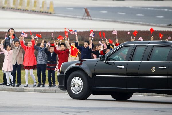 Trẻ em chào đón đoàn xe của Tổng thống Mỹ Donald Trump và Đệ nhất phu nhân Melanie tại sân bay Bắc Kinh, Trung Quốc - Sputnik Việt Nam