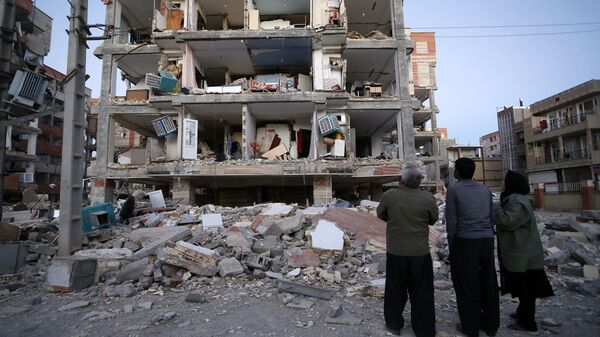 Mọi người nhìn tòa nhà bị động đất phá hủy ở thành phố Sere-Polye Zohab, Iran - Sputnik Việt Nam