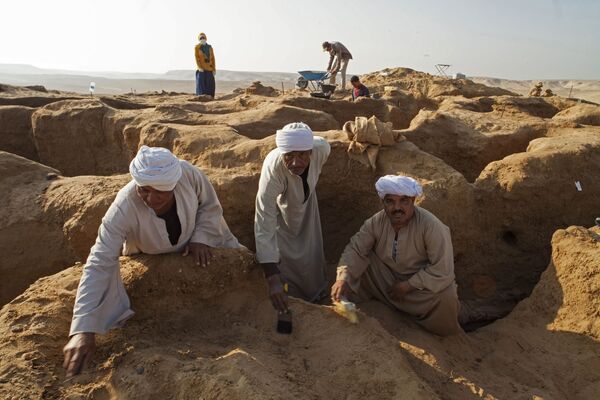 Các công  nhân làm sạch di chỉ  khai quật ở Deir El Banat trên  ốc đảo El Faiyum thuộc Ai Cập, nơi tìm thấy xác ướp với mặt nạ giấy sậy vàng trong cuộc khai quật do Trung tâm Nghiên cứu Ai Cập thuộc Viện Hàn lâm Khoa học Nga tiến hành. - Sputnik Việt Nam