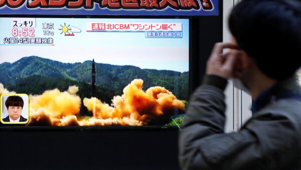 Трансляция новости о запуске северокорейской баллистической ракеты на одной из улиц Токио, Япония - Sputnik Việt Nam