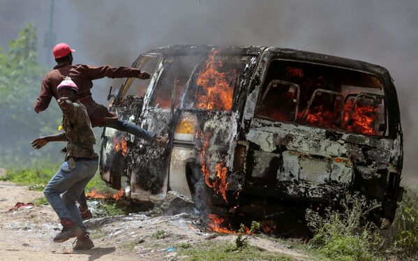 Những người ủng hộ phong trào đối lập Kenya Siêu liên minh Quốc gia gần chiếc xe bị đốt cháy ở Embakasi, Kenya - Sputnik Việt Nam