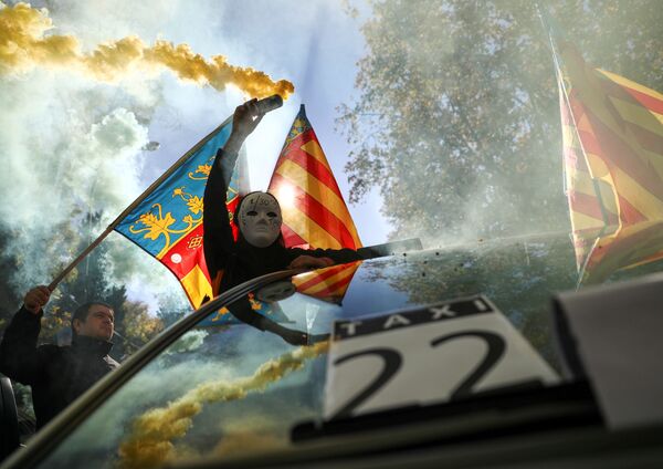 Một người đàn ông đeo mặt nạ và một quả bom khói trong cuộc đình công của các tài xế taxi ở Madrid - Sputnik Việt Nam