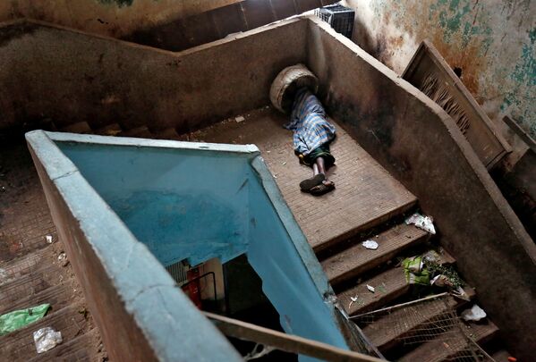 Một người ăn xin ngủ trên bậc thang tại chợ bán buôn ở Bangalore, Ấn Độ - Sputnik Việt Nam