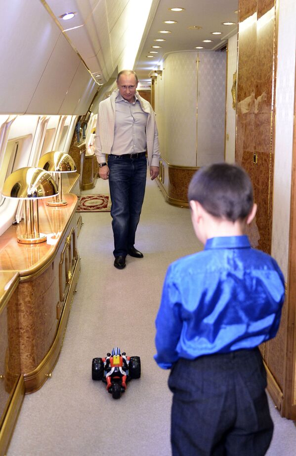 Tổng thống Nga Vladimir Putin xem chiếc xe điều khiển bằng radio cùng với con trai út của hạ sĩ Baira Banzaraktsayev hy sinh ở Khabarovsk, năm 2013 - Sputnik Việt Nam
