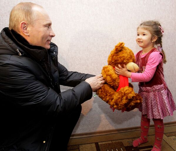 Ông Vladimir Putin khi là Thủ tướng Nga tặng con gấu bông cho bé gái ở Vùng Krasnodar, năm 2011 - Sputnik Việt Nam