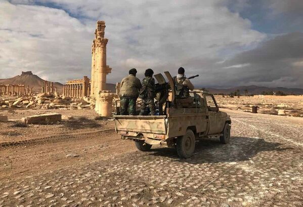 Quân nhân chính phủ Syria bên cạnh tổ hợp lịch sử-kiến trúc cổ Palmyra, tỉnh Homs, Syria. - Sputnik Việt Nam