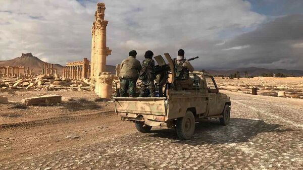 Quân nhân chính phủ Syria bên cạnh tổ hợp lịch sử-kiến trúc cổ Palmyra, tỉnh Homs, Syria. - Sputnik Việt Nam