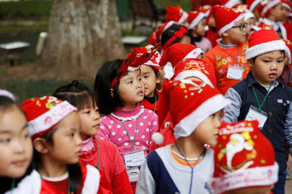 Các em nhỏ mặc trang phục Ông già Noel chơi  bên Hồ Hoàn Kiếm ở Hà Nội, Việt Nam - Sputnik Việt Nam