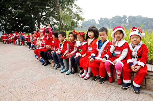 Các em nhỏ trong trang phục Ông già Noel bên Hồ Hoàn Kiếm ở Hà Nội, Việt Nam - Sputnik Việt Nam