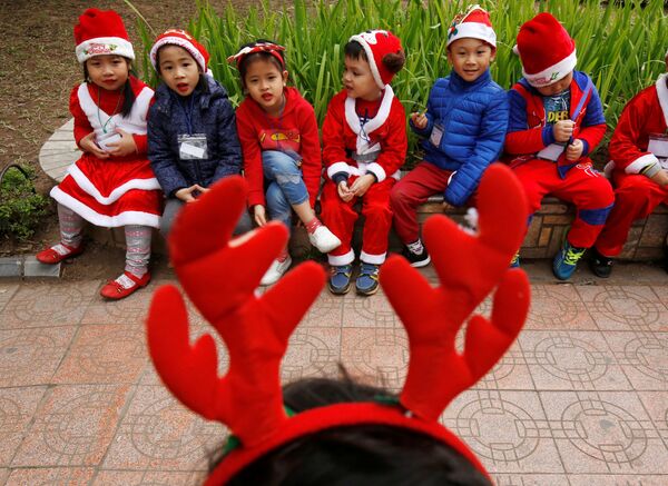 Các em bé trong trang phục Ông già Noel bên Hồ Hoàn Kiếm ở Hà Nội, Việt Nam - Sputnik Việt Nam