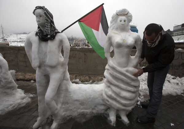 Một cư dân Palestine trong lúc đắp Người tuyết ở Jerusalem - Sputnik Việt Nam