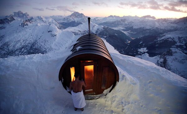 Một người đàn ông đi vào phòng tắm hơi trên núi Lagazui ở Cortina d'Ampezzo, Ý - Sputnik Việt Nam