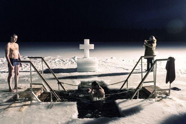 Các tín hữu trong thời gian lễ tắm truyền thống ở hố nước băng trên lãnh thổ Tu viện nam Hồ thiêng Đức Mẹ Valdai Iver ở ngoại ô Novgorod - Sputnik Việt Nam