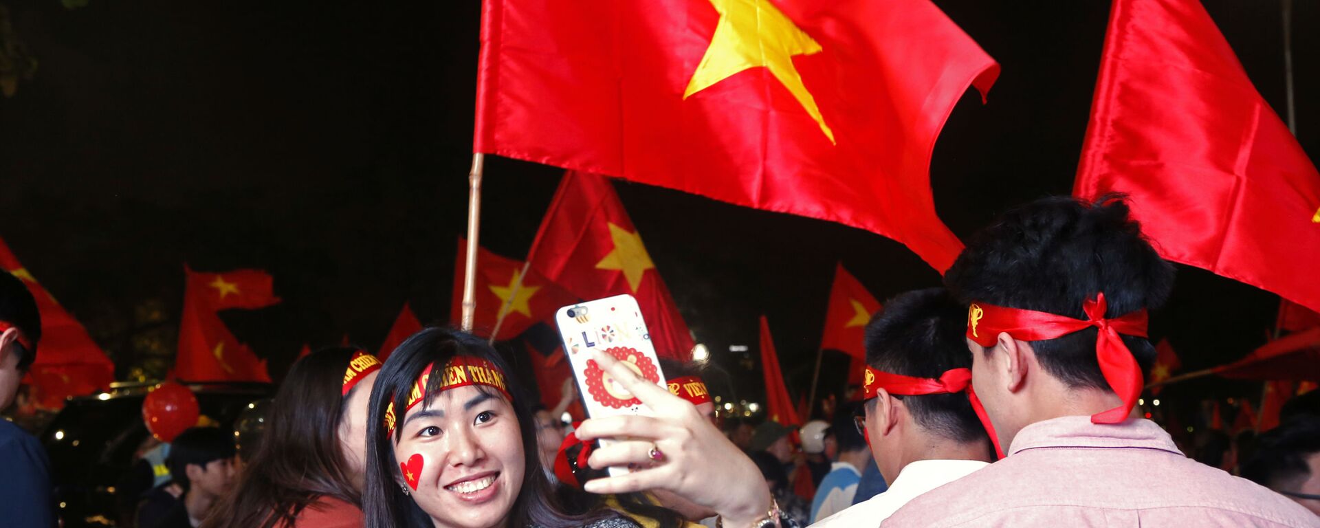 Người hâm mộ bóng đá Việt Nam vui sướng mừng chiến thắng của đội tuyển nước nhà tiến vào trận chung kết giải  Vô địch Châu Á U 23. - Sputnik Việt Nam, 1920, 05.05.2022