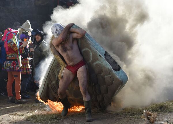 Người đeo mặt nạ mang chiếc nệm cháy trong Karnaval thường niên ở làng Zubieta, bắc Tây Ban Nha - Sputnik Việt Nam