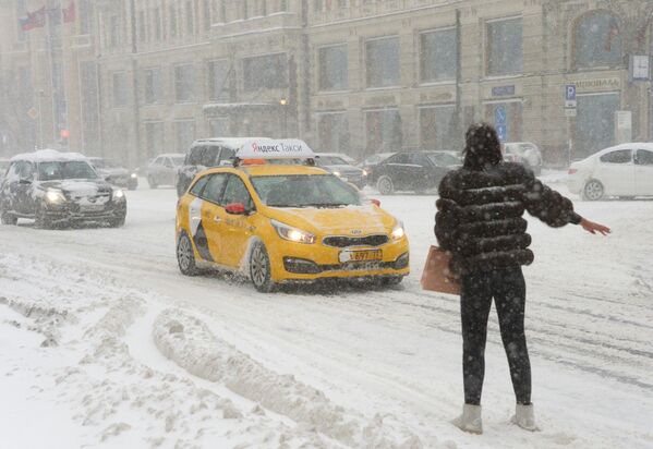 Một cô gái bắt xe taxi trên phố Tverskaya trong thời gian tuyết rơi - Sputnik Việt Nam