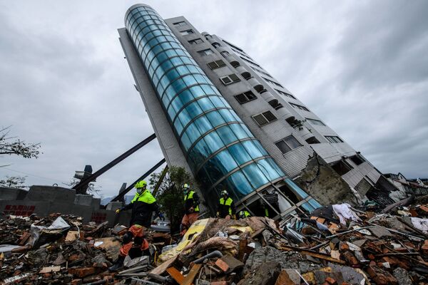 Nhân viên cứu hộ rời khỏi tòa nhà Yun Tsui, dựa trên loạt cột chống đỡ sau trận động đất ở thành phố Hualien, Đài Loan - Sputnik Việt Nam