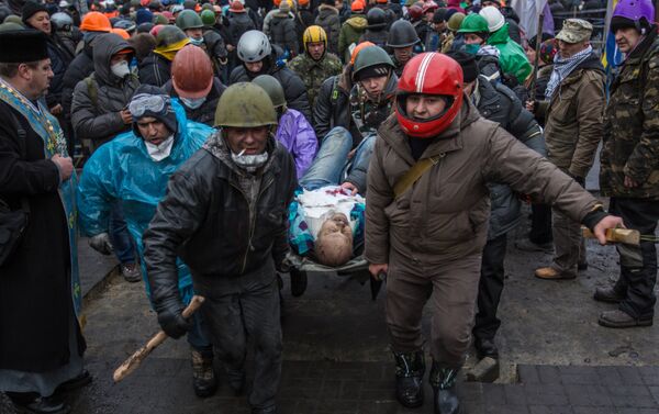 Phái ủng hộ đối lập mang người bị thương vì đụng độ với nhân viên thực thi pháp luật ra quảng trường Maidan ở Kiev. - Sputnik Việt Nam
