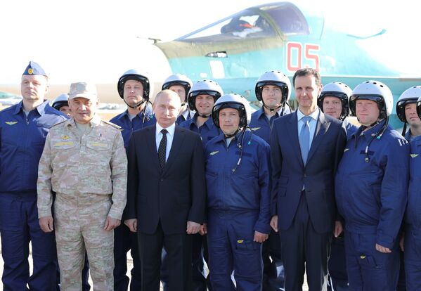 Tổng thống Nga Vladimir Putin và Tổng thống Syria Bashar al-Assad cùng các quân nhân Nga trong chuyến thăm căn cứ không quân Hmeimim ở Syria - Sputnik Việt Nam